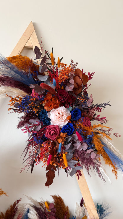 Dried wedding arch flowers in moody burgundy, terracotta and navy blue tone