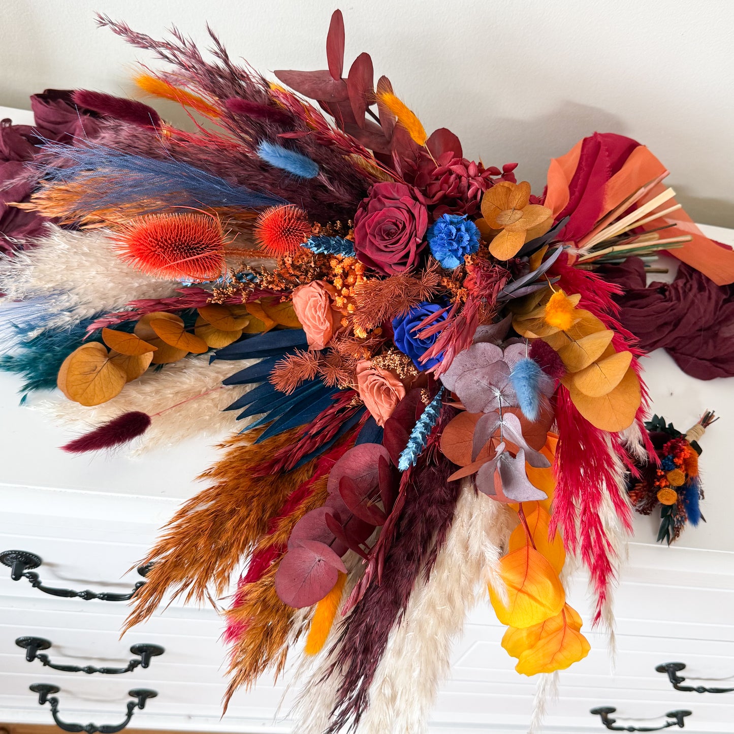 Dried bridal bouquet featuring burgundy, terracotta, navy blue and blush preserved flowers
