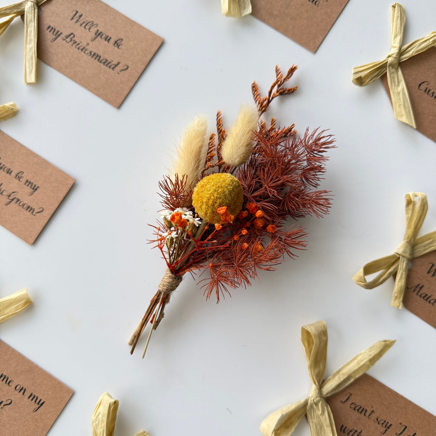Dried flower bouquet with 'Will you be my bridesmaid?' cards on a white background