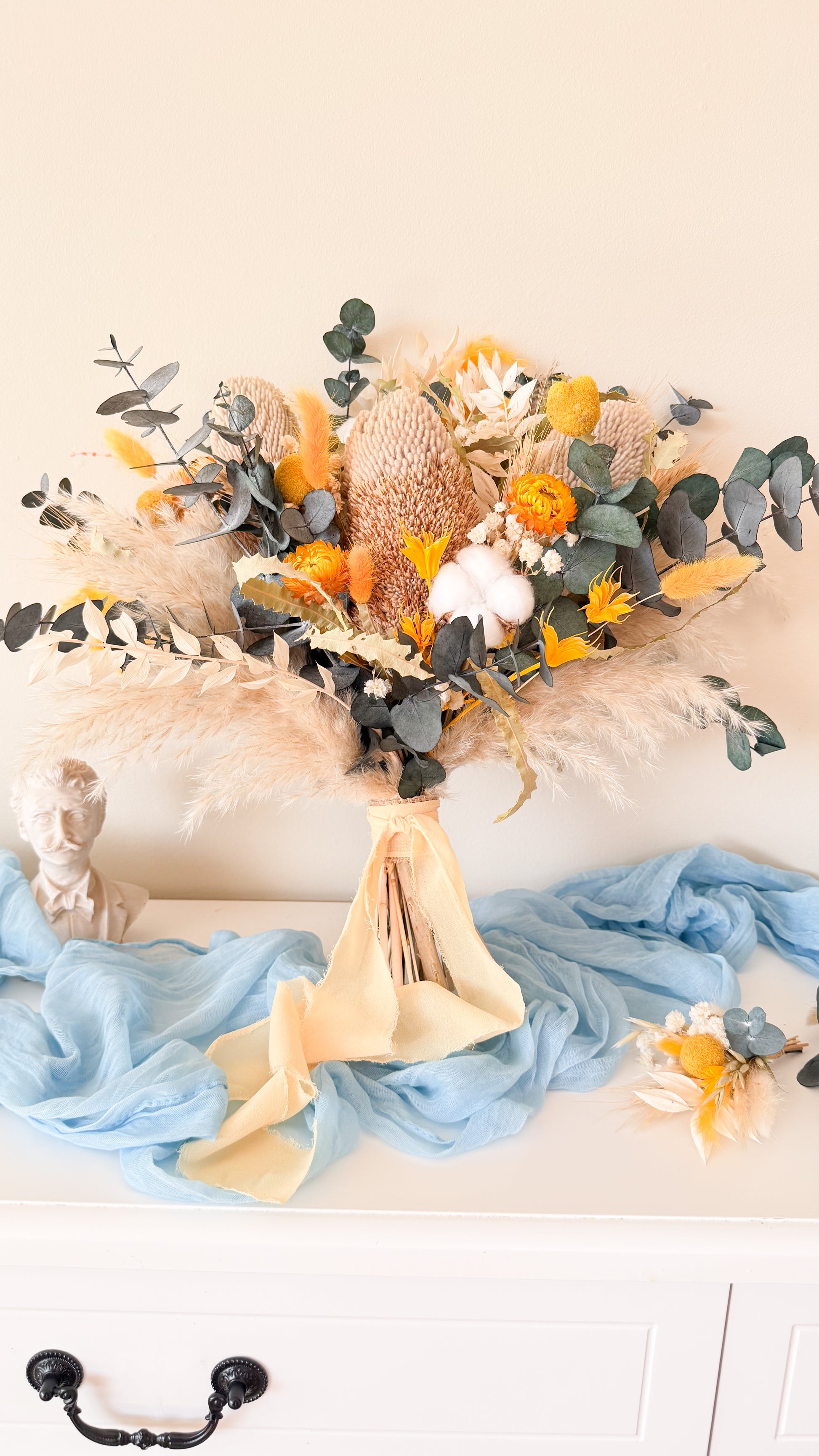 Minimalist boho dried flower bouquet with neutral tones, blue fabric and pampas grass