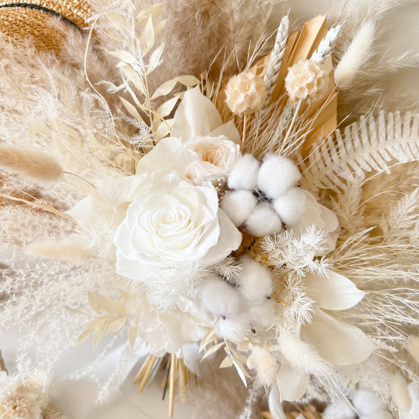 Neutral dried bridal bouquet with ivory preserved rose, cotton bolls and pampas grass in soft boho wedding style.