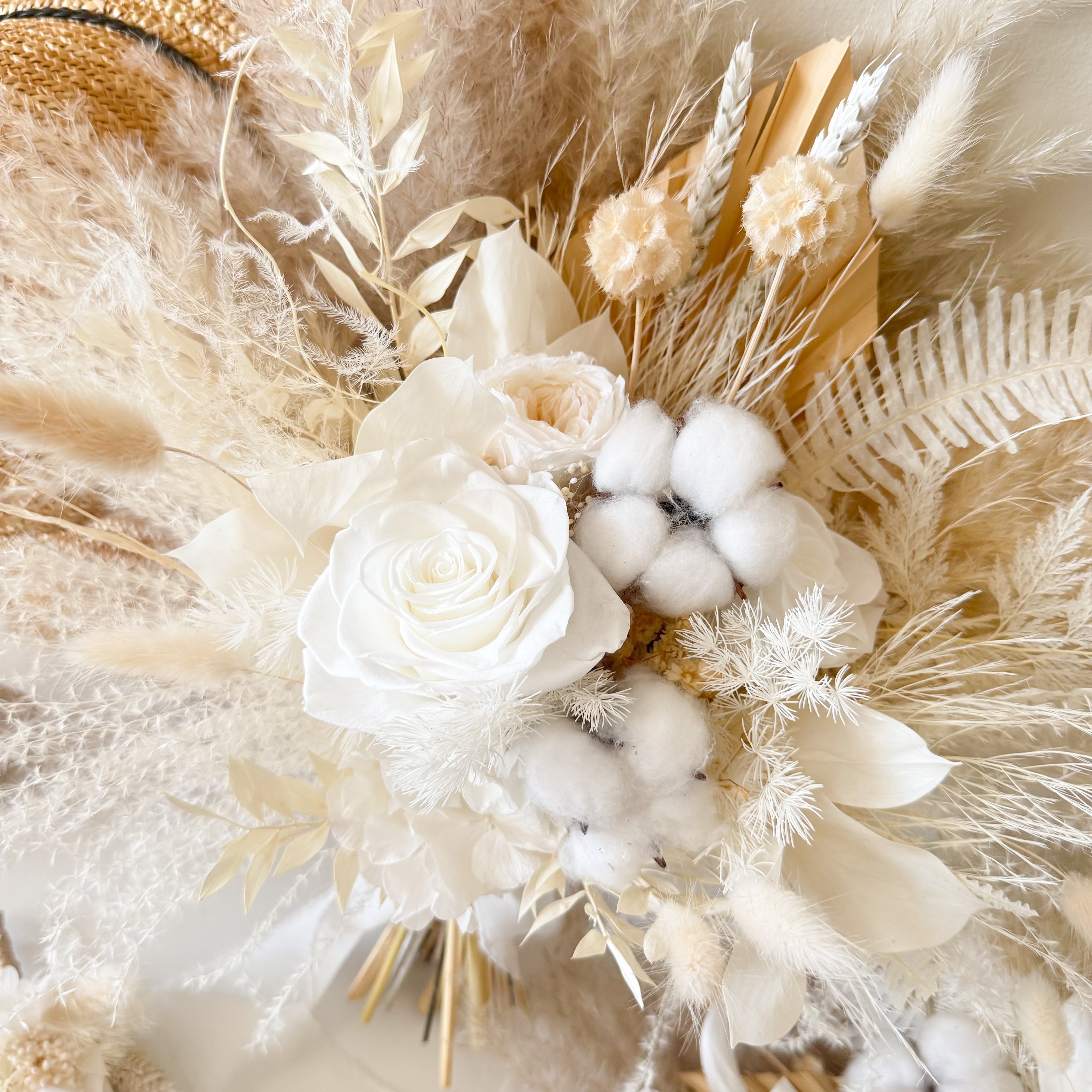 Neutral dried bridal bouquet with ivory preserved rose, cotton bolls and pampas grass in soft boho wedding style.