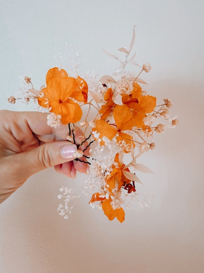 Orange and white dried flower bridal hair pins with preserved hydrangea and delicate baby’s breath for a wedding hairstyle