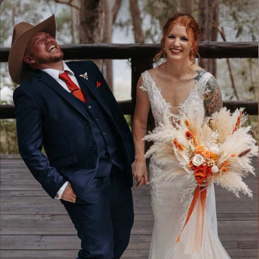 Bride holding a white and burnt orange dried flower bouquet with pampas grass and preserved flowers at a rustic Australian wedding