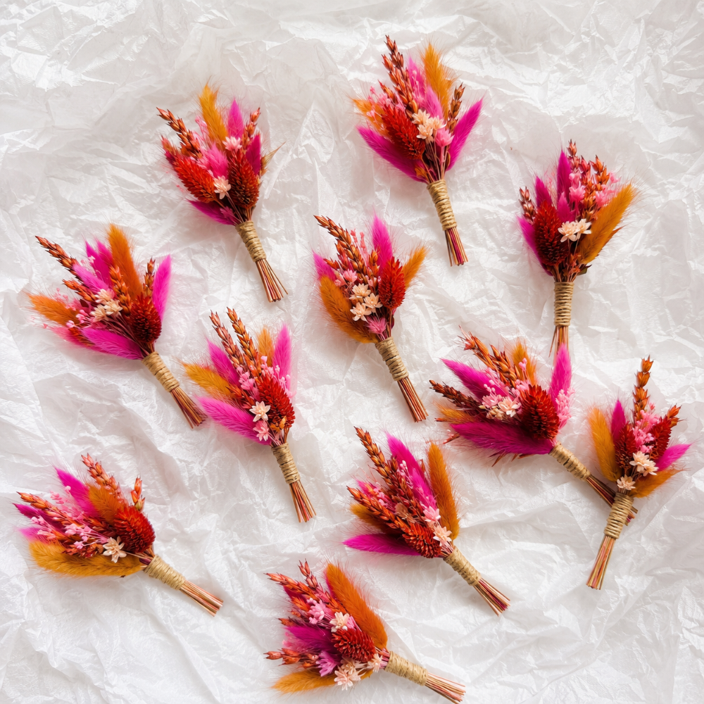 Bulk order of handmade pink dried flower boutonnieres with preserved flowers and wheat, wedding favors for guests and bridal party accessories.