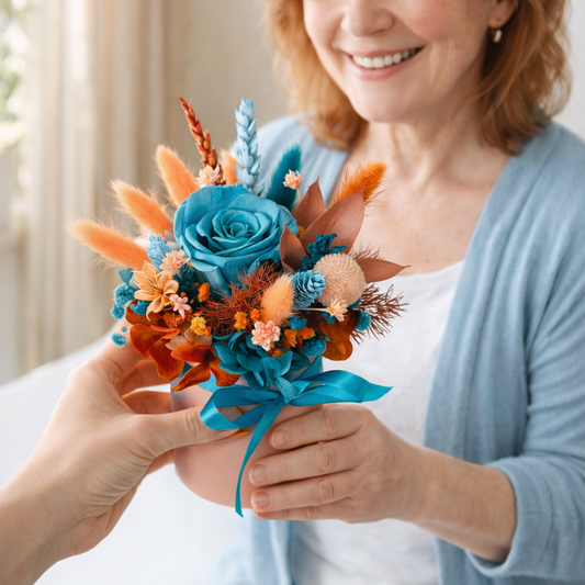 Woman holding preserved rose flower arrangement with turquoise and orange dried flowers handmade gift