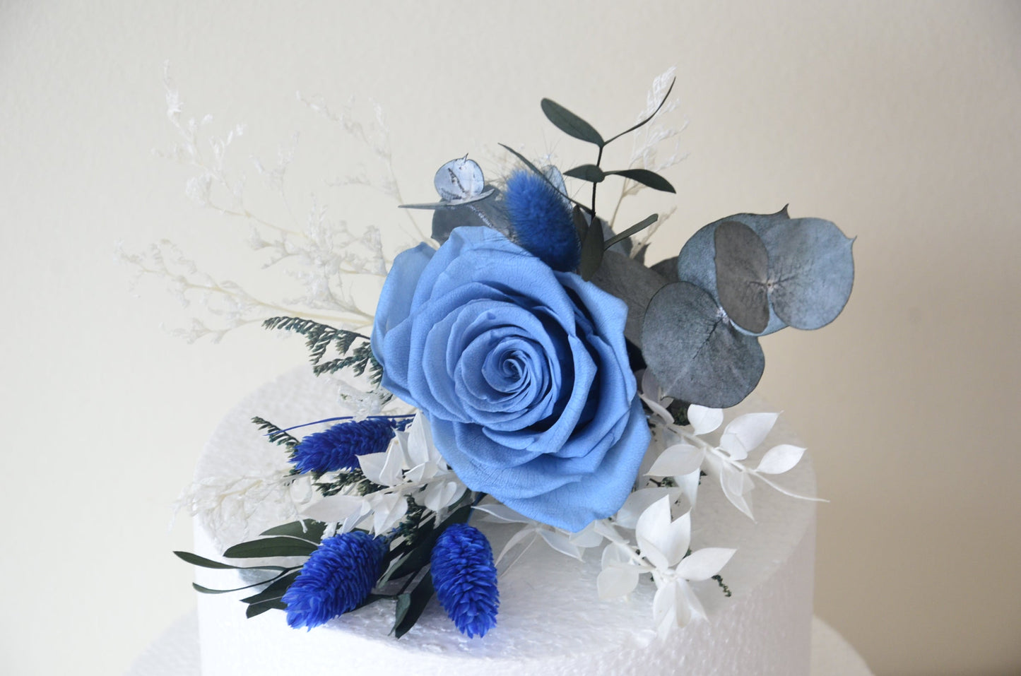 Close-up of preserved blue rose and thistle cake decoration – perfect for elegant weddings in Sydney