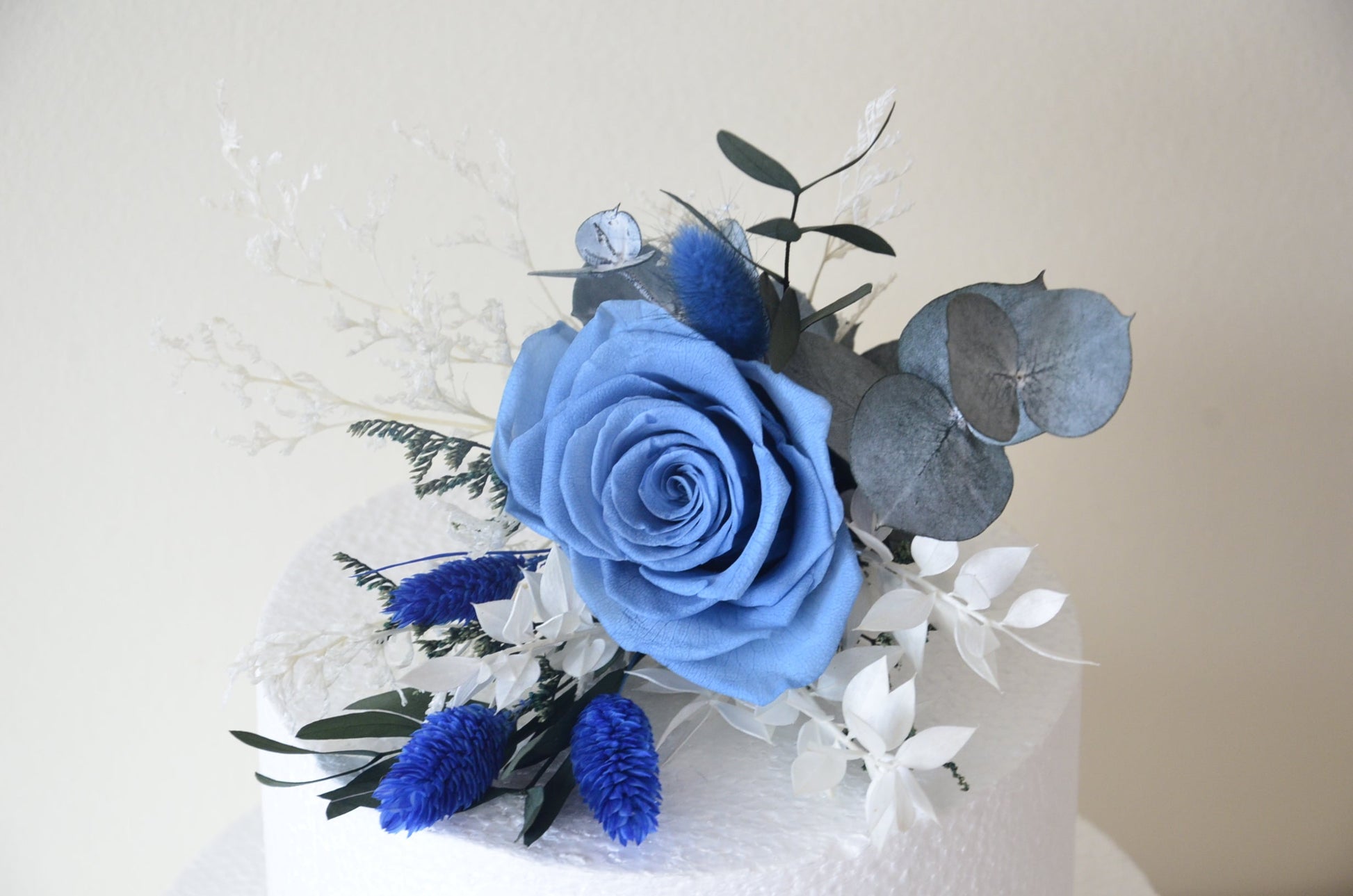 Close-up of preserved blue rose and thistle cake decoration – perfect for elegant weddings in Sydney
