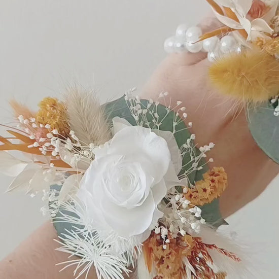 Boho wedding wrist corsage pair in white, mustard, and sage tones with artificial roses and dried florals

