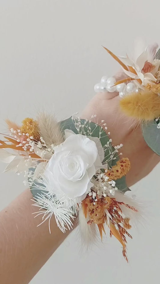 Boho wedding wrist corsage pair in white, mustard, and sage tones with artificial roses and dried florals


