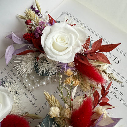 Decorative floral corsage with a white rose on top of a book