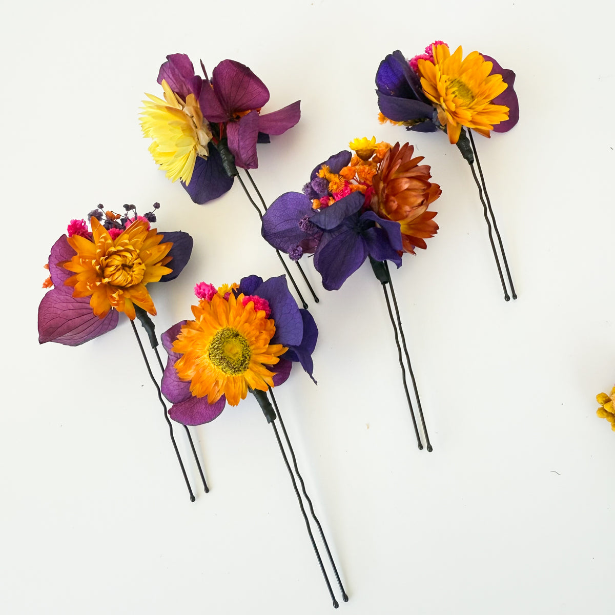 Purple and orange dried flower bridal hair pins with preserved hydrangea and colourful flowers for a wedding hairstyle
