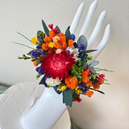 Handmade wedding corsage with red and orange dried flowers, perfect natural accessory for bridesmaids and guests