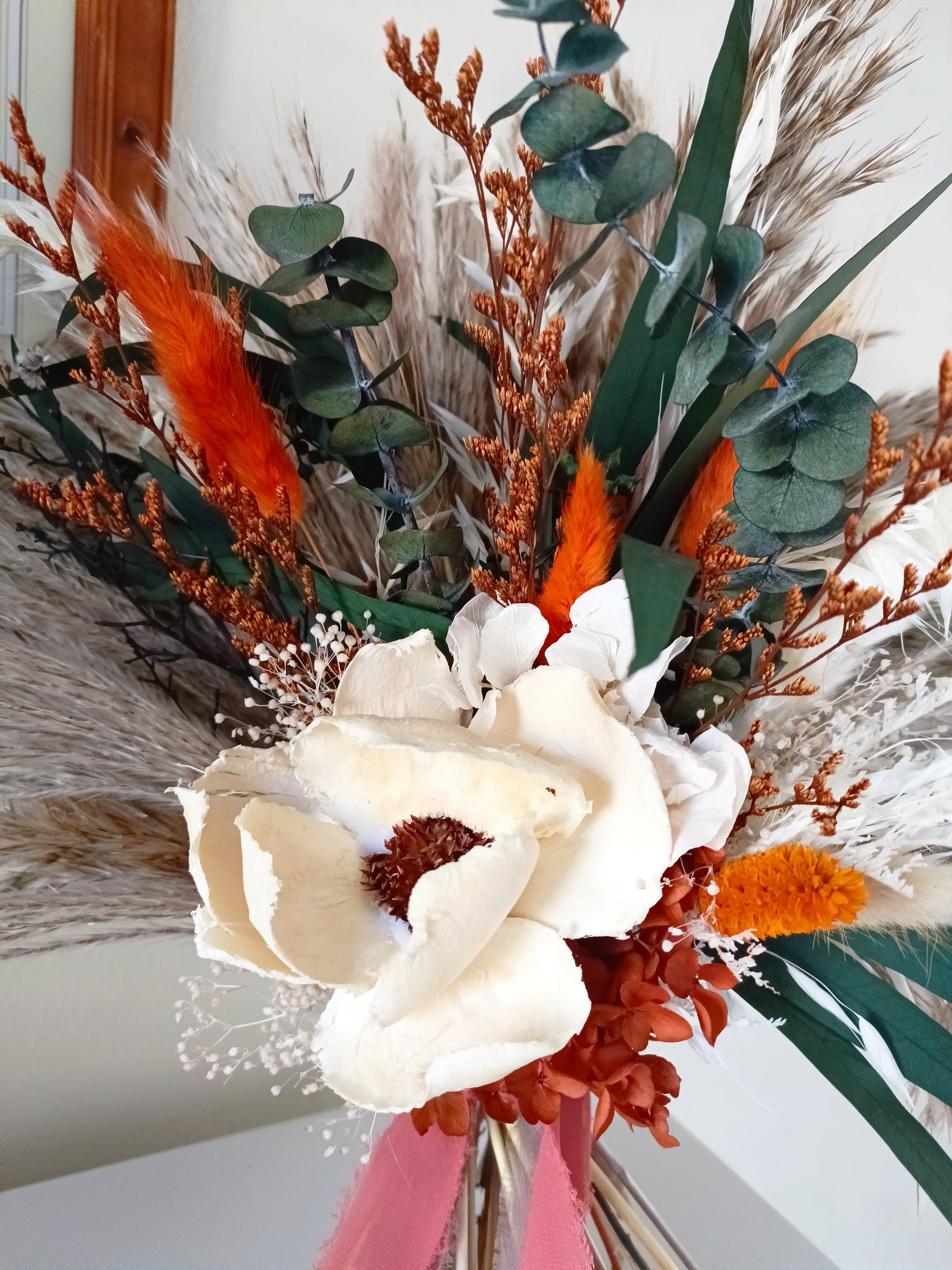 Sola Flower Bouquet with Green Eucalyptus, Pampas Grass, and Orange Hues Add a touch of natural elegance to any occasion with our Sola Flower Bouquet, featuring green eucalyptus, pampas grass, and vibrant orange hues. Handcrafted with care, this bouquet combines the delicate beauty of sola flowers with the rustic charm of pampas grass and the fresh scent of eucalyptus.