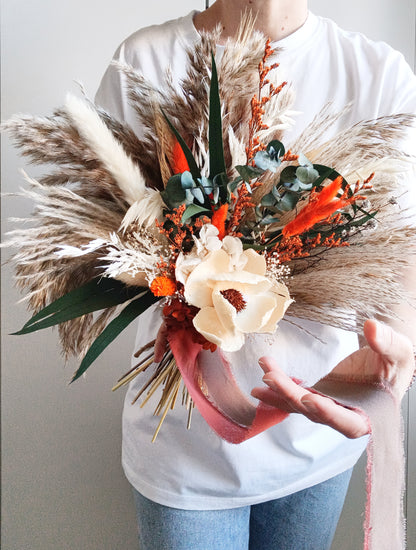 Sola Flower Bouquet with Green Eucalyptus, Pampas Grass, and Orange Hues Add a touch of natural elegance to any occasion with our Sola Flower Bouquet, featuring green eucalyptus, pampas grass, and vibrant orange hues. Handcrafted with care, this bouquet combines the delicate beauty of sola flowers with the rustic charm of pampas grass and the fresh scent of eucalyptus.