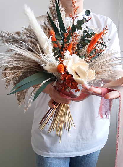 Sola Flower Bouquet with Green Eucalyptus, Pampas Grass, and Orange Hues Add a touch of natural elegance to any occasion with our Sola Flower Bouquet, featuring green eucalyptus, pampas grass, and vibrant orange hues. Handcrafted with care, this bouquet combines the delicate beauty of sola flowers with the rustic charm of pampas grass and the fresh scent of eucalyptus.