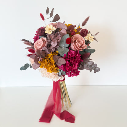 Romantic bridal bouquet with dried flowers in blush pink, cream, and mustard tones, ideal for boho rustic weddings.