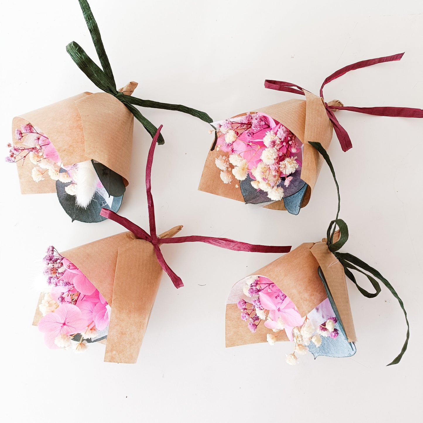 Preserved pink flower mini bouquets with rustic wrapping, sustainable and long-lasting wedding gifts.