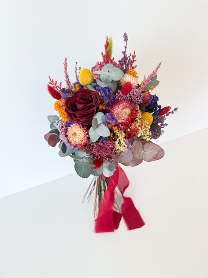 Rustic terracotta and burgundy bridal bouquet with preserved eucalyptus, golden yellow strawflowers, and soft lilac accents