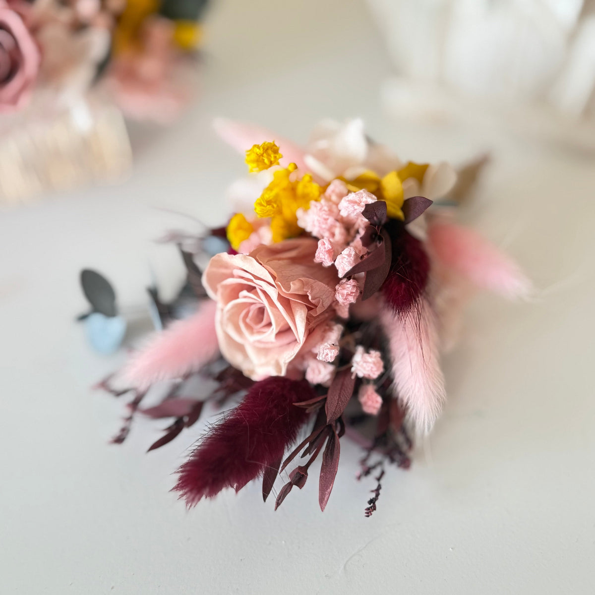 Floral arrangement with pink and yellow flowers on a light background