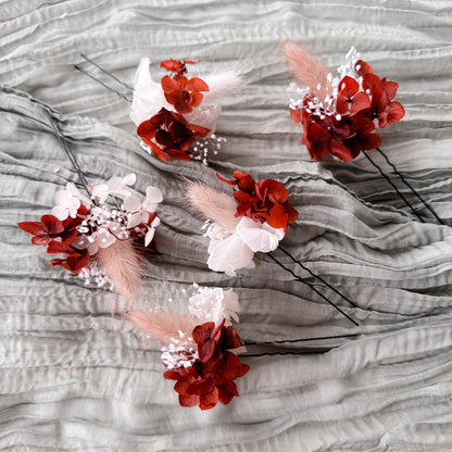 terracotta and white floral hair pins on a textured gray surface