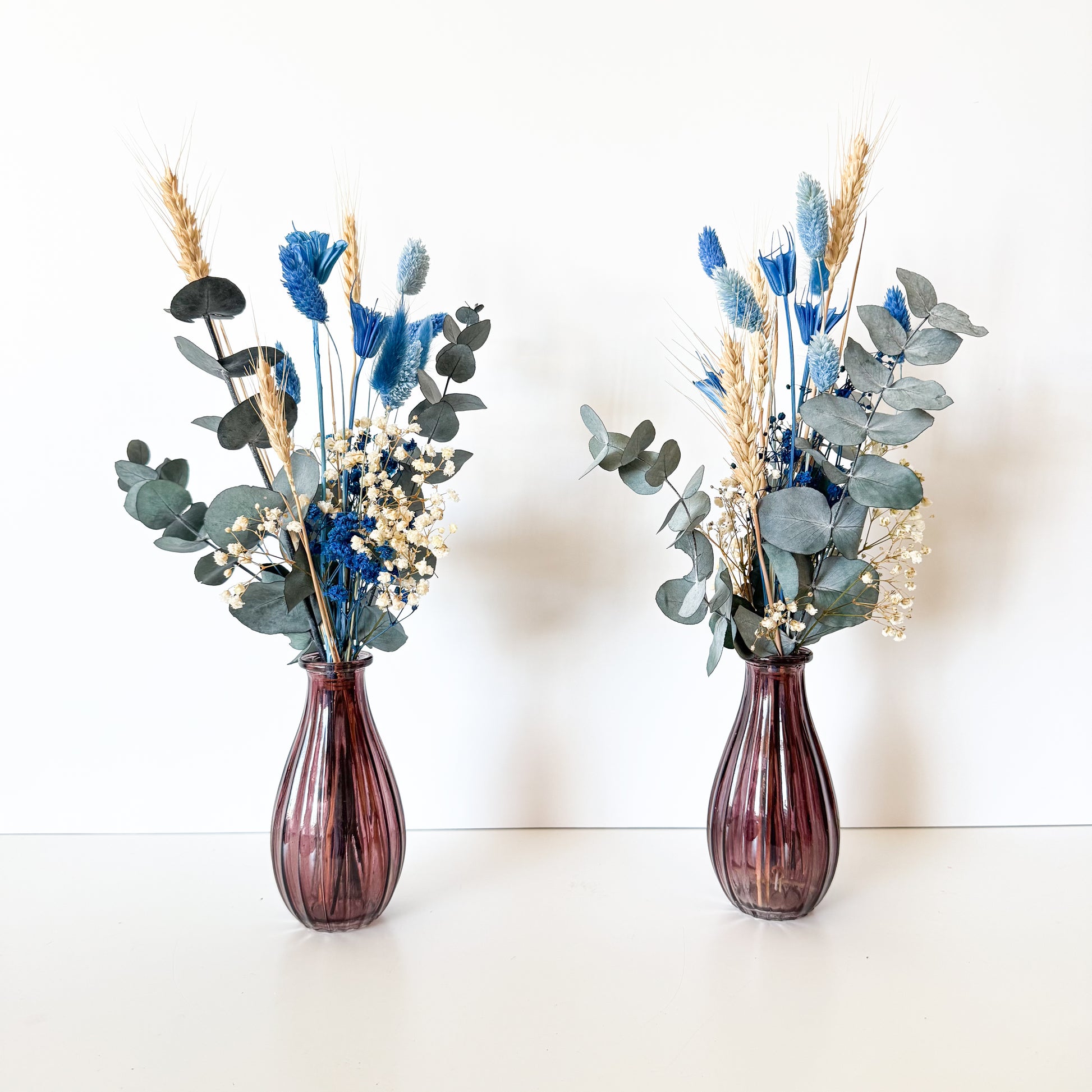 Small dusty blue dried flower vase arrangements with preserved eucalyptus and wheat, handmade for wedding decor or gifts.