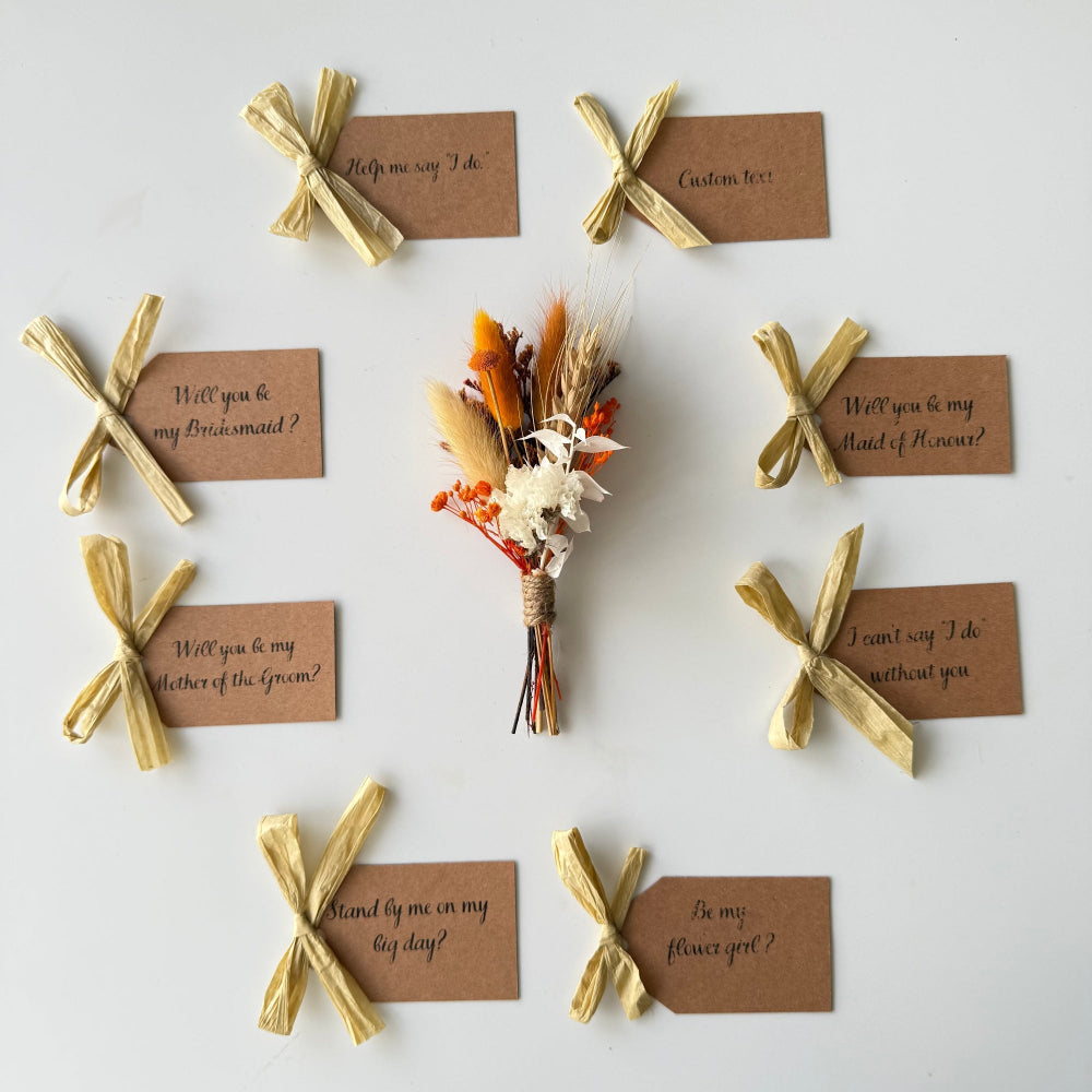 Set of wedding proposal cards with gold ribbons and a small bouquet on a white background