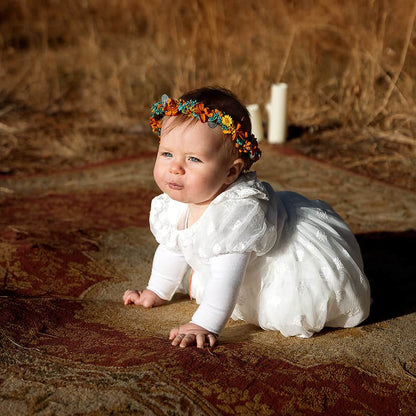 Flower girl wearing sunflower and teal dried flower crown for boho wedding