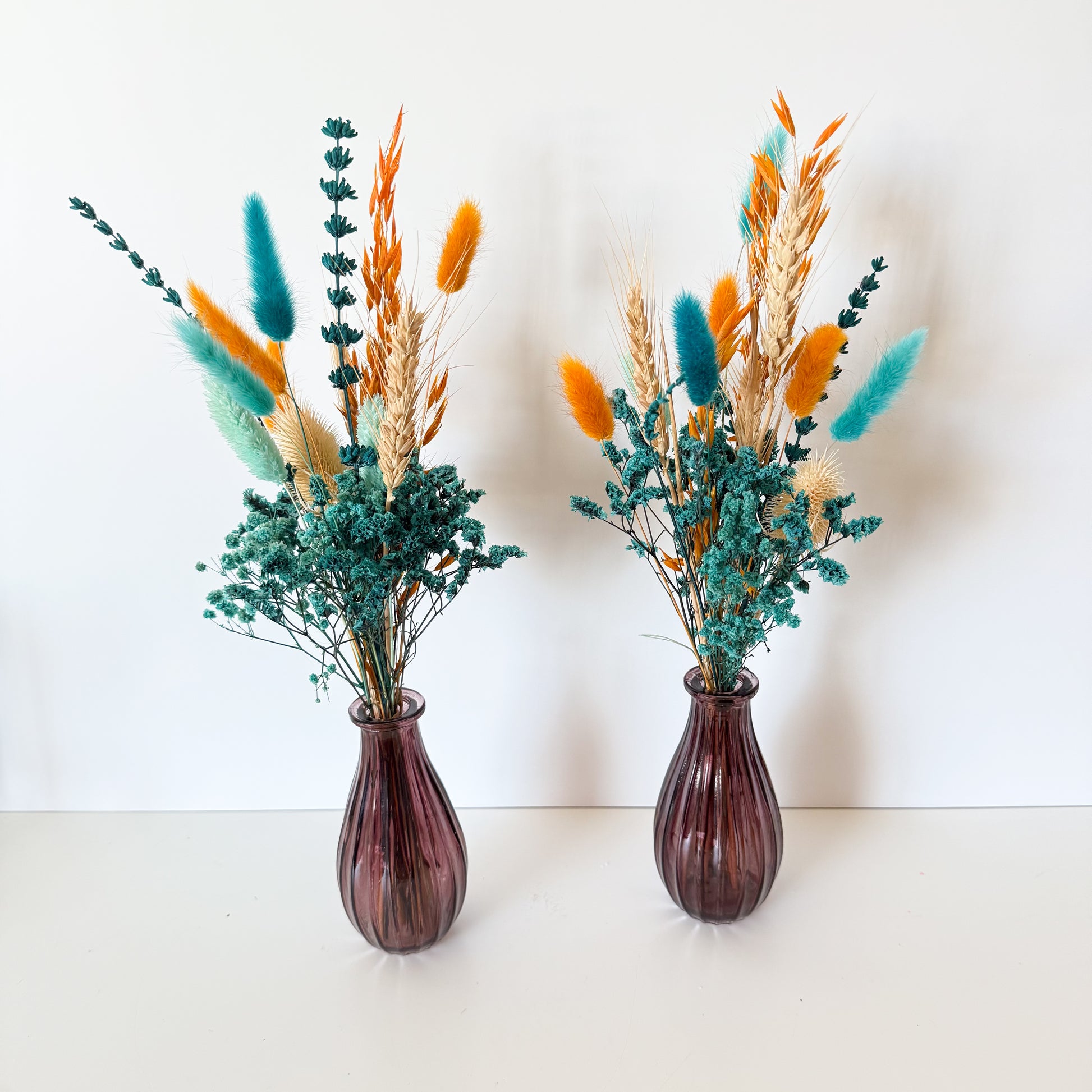 teal dried floral arrangements on a white background