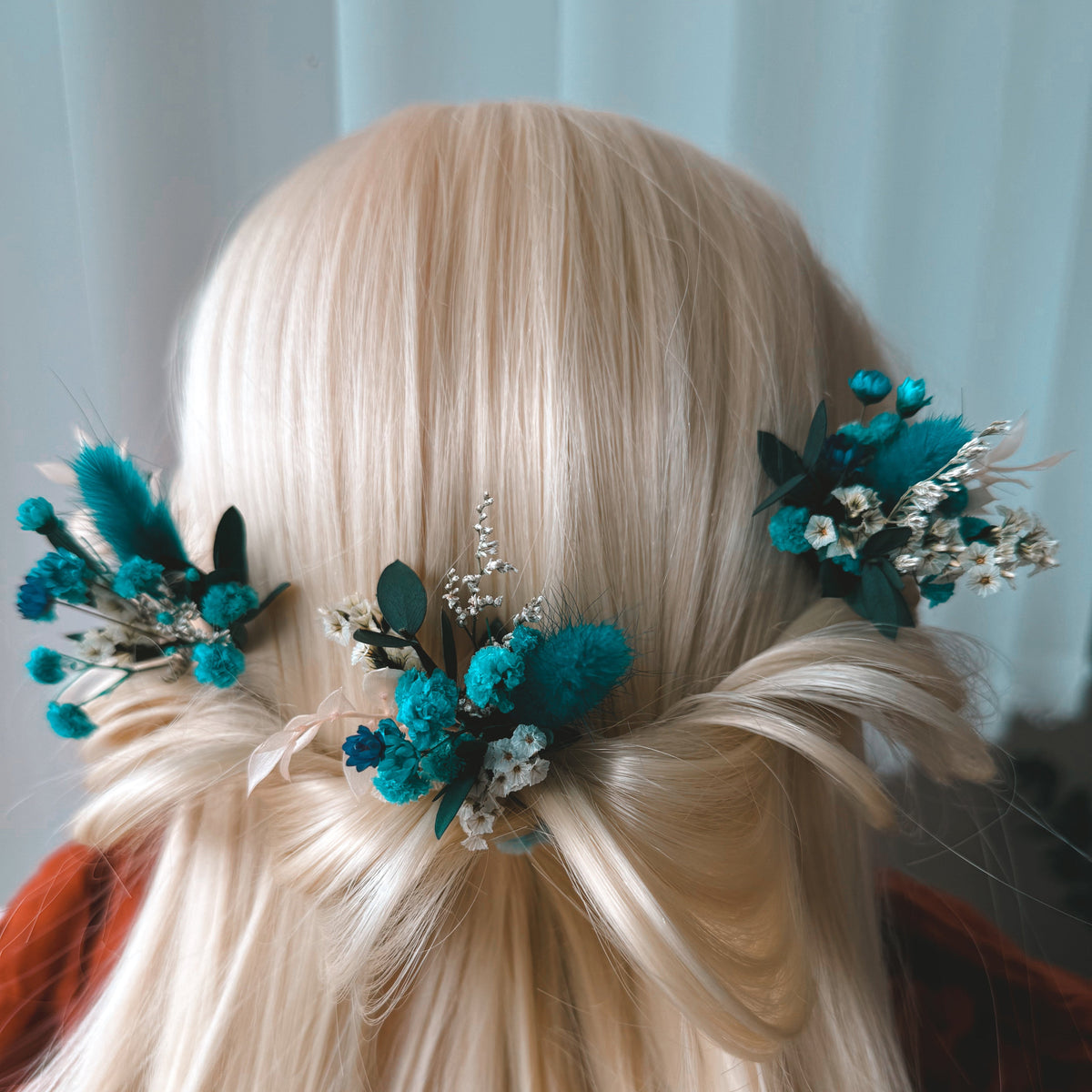 Teal blue dried flower bridal hair pins with preserved flowers and greenery styled in a romantic wedding hairstyle