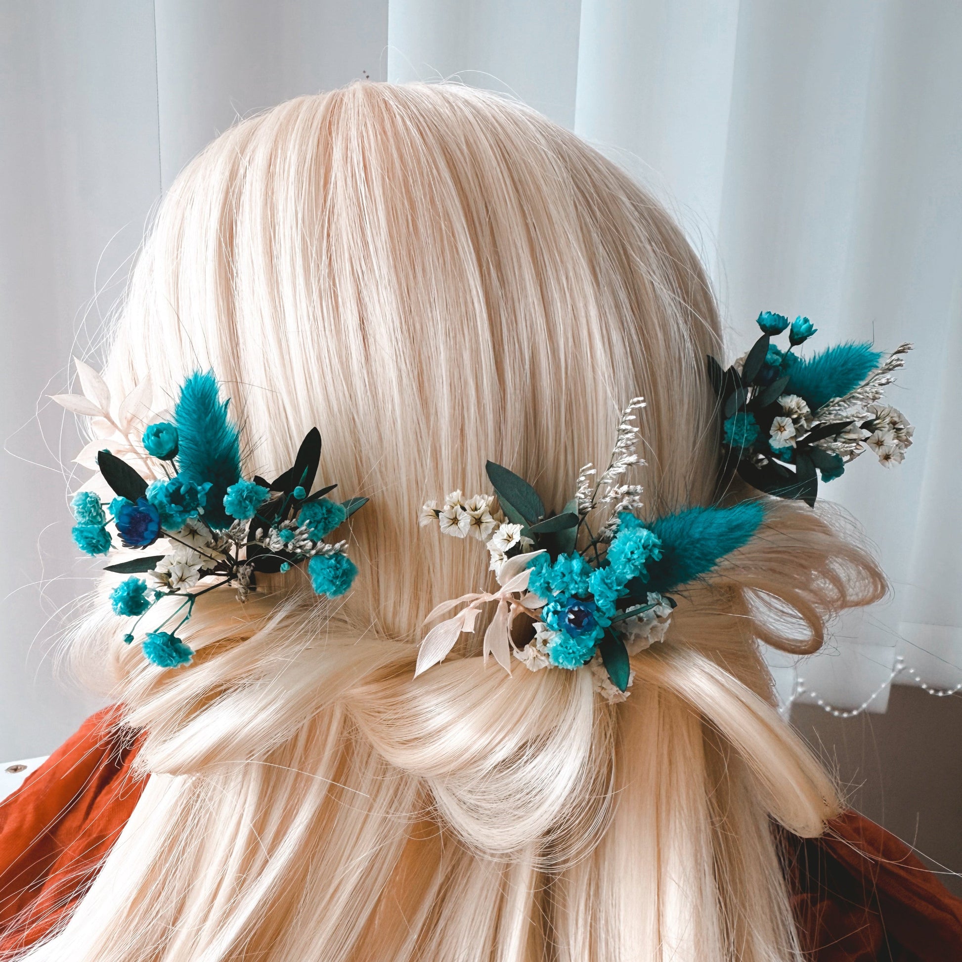 Teal blue dried flower bridal hair pins with preserved flowers and foliage styled in a romantic wedding hairstyle