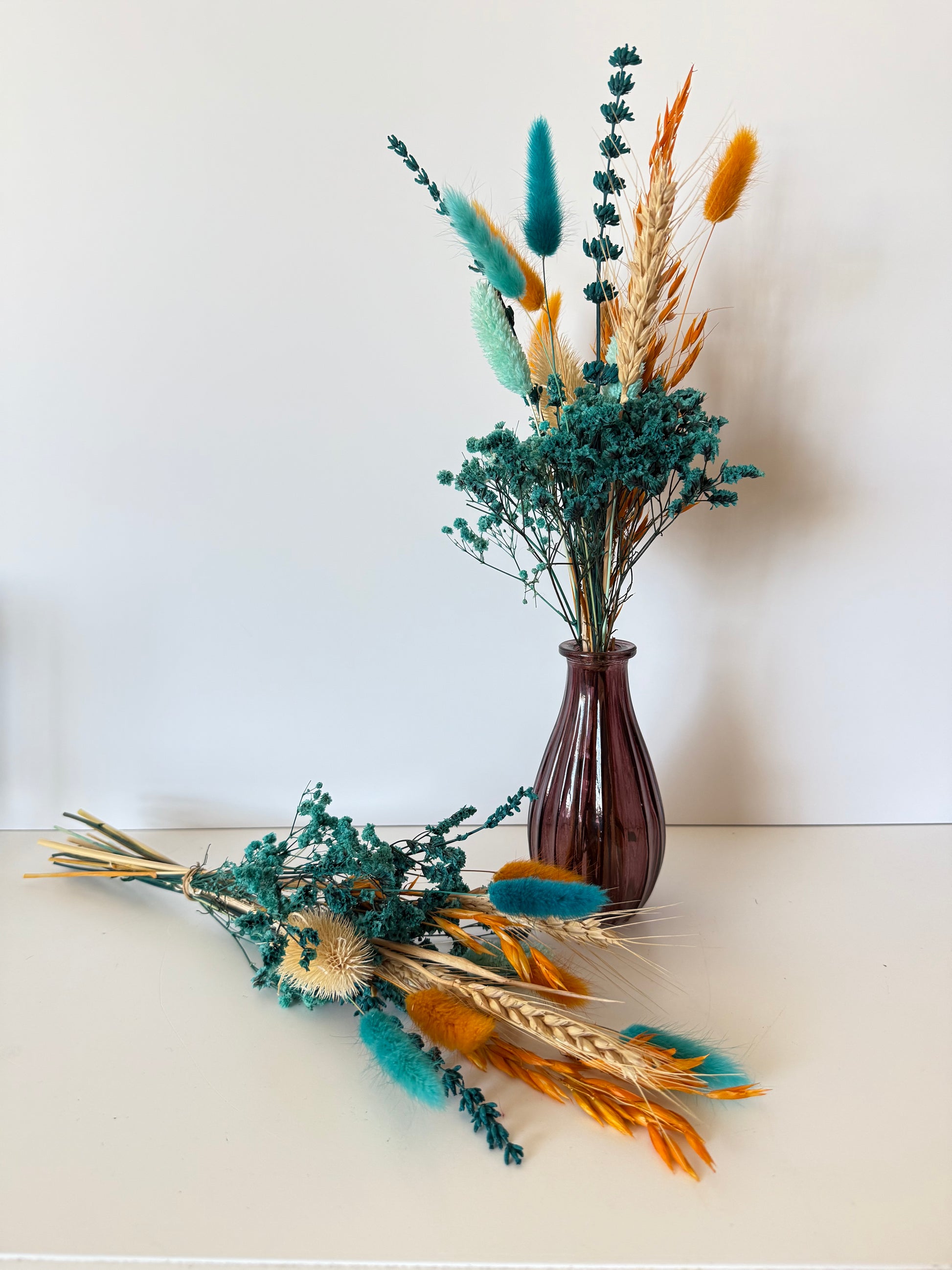 Teal eucalyptus with orange bunny tails and dried grass arrangement, minimalist natural decor for home or office space