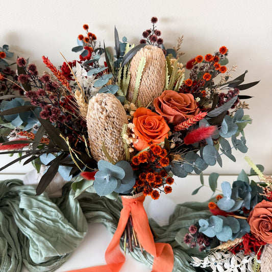 Terracotta Australian native bridal bouquet featuring preserved roses, banksia, eucalyptus and dried flowers in burnt orange, rust and blue-green tones, handmade wedding bouquet in Australia