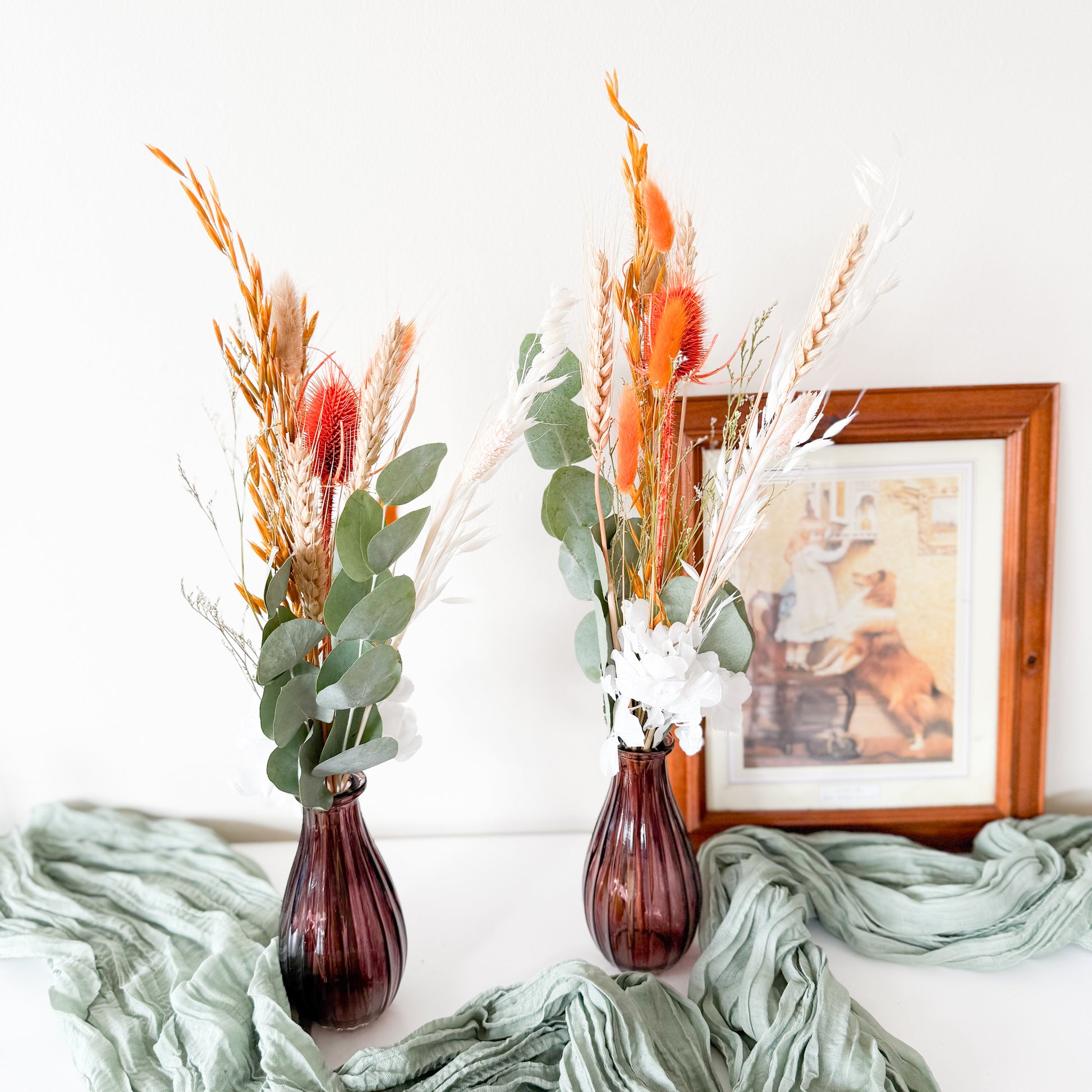 Set of two dried flower arrangements with orange bunny tails, eucalyptus, and white accents, perfect for boho home decor or wedding styling