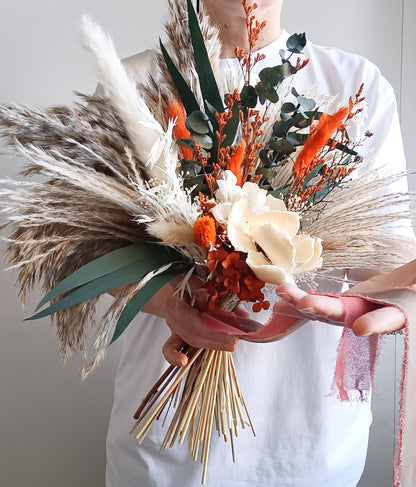 Australian dried wedding bouquet in terracotta and ivory shades with preserved leaves, sola flowers, and pampas – perfect for boho brides