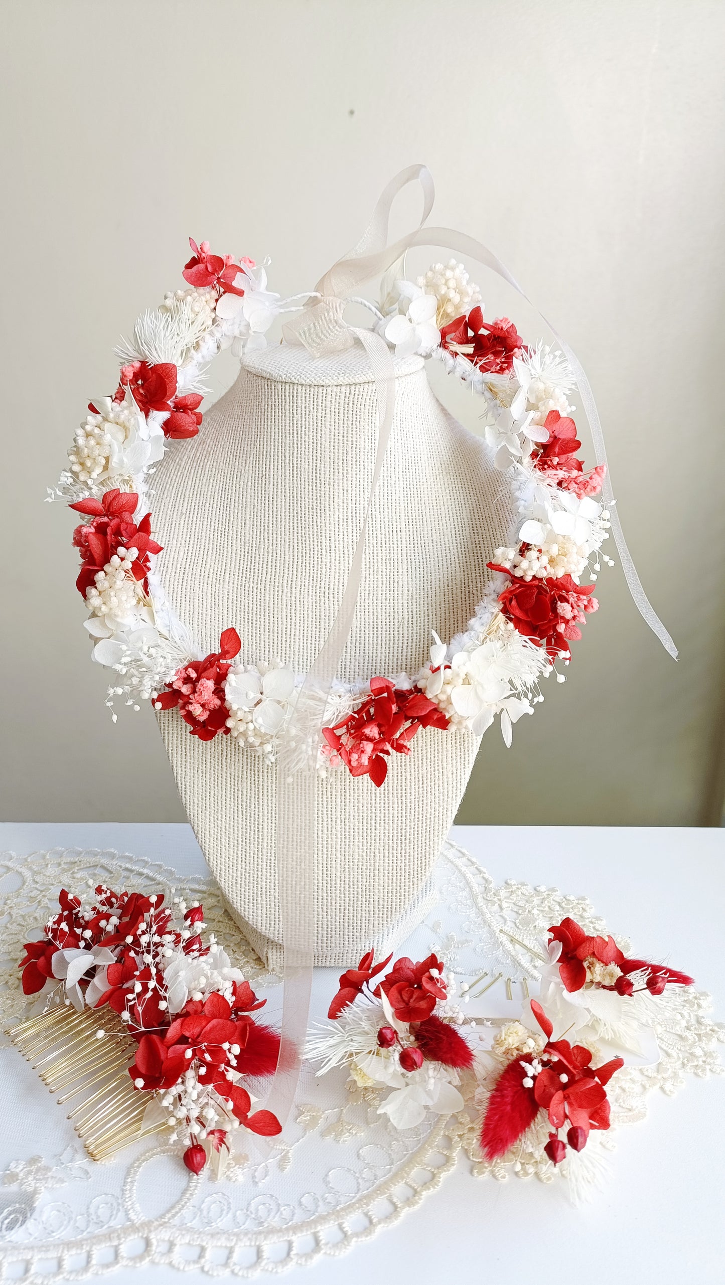  A delicate dried flower crown featuring a bold mix of red and white petals, adorned with tiny pearl accents. The wreath is tied with sheer ribbon, creating an elegant, romantic look for a wedding or special occasion.