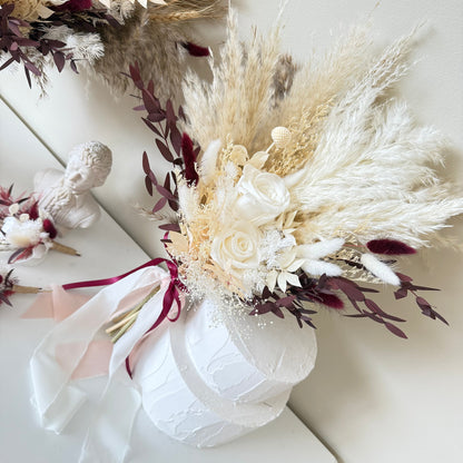 Bouquet of dried flowers with pampas grass and white roses in a white box on a light background