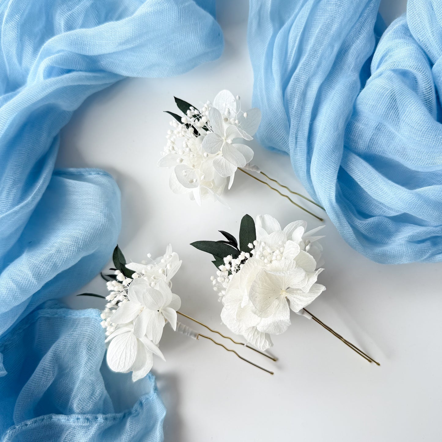 Floral hairpins with blue fabric on a white background
